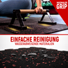 Die obere Bildhälfte zeigt eine Person, die auf einer schwarzen Trainingsmatte mit roten Sprenkeln liegt und sich auf Parallettes stützt, mit dem Text "Maximaler Grip". In der unteren Bildhälfte sind Wassertröpfchen auf der Matte zu sehen, was die wasserabweisenden Materialien und die einfache Reinigung hervorhebt, begleitet von der Aufschrift "Einfache Reinigung - Wasserabweisende Materialien".