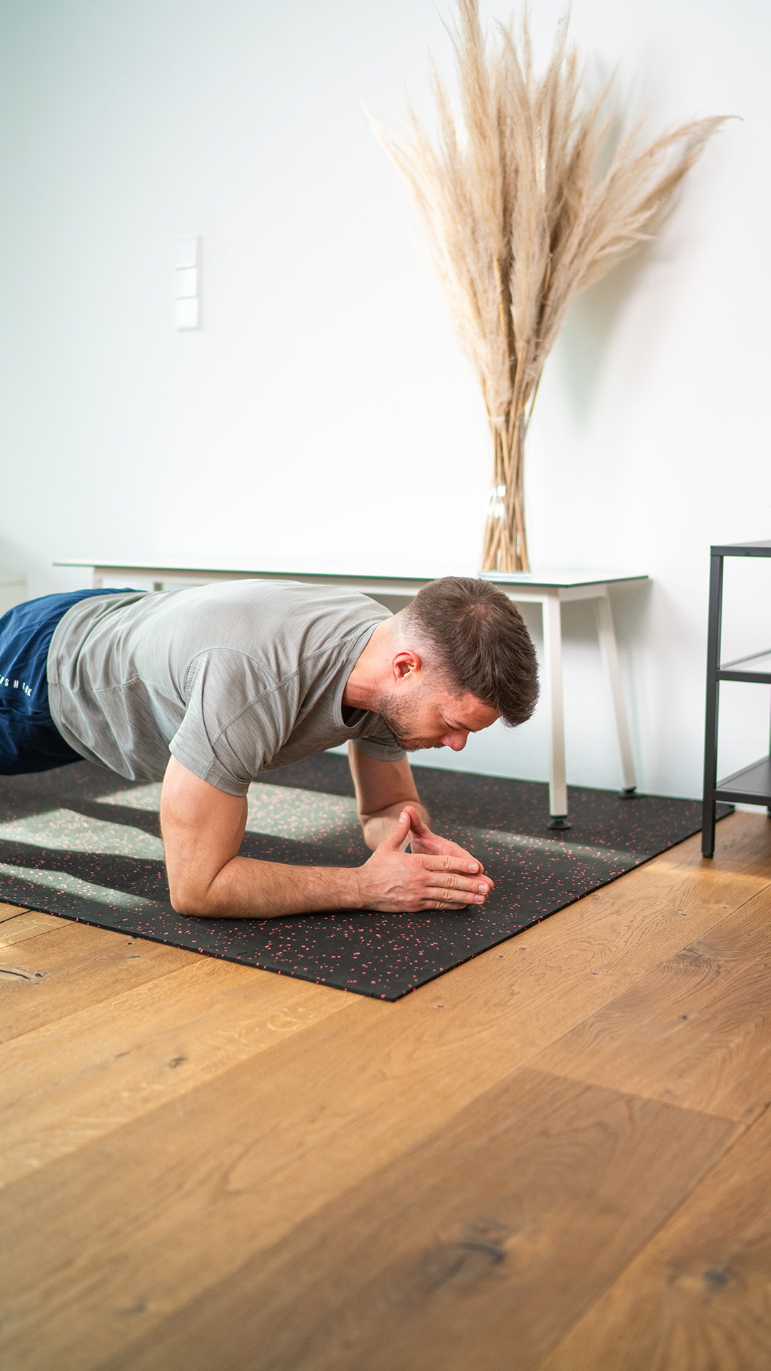 Mann hält eine Plank-Position auf einer Fitnessmatte. Fokus auf Core-Stabilität und Körperspannung. Perfekt für ein effektives Ganzkörpertraining im Homegym.